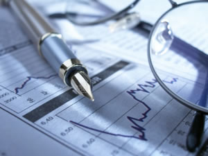 image of pen and glasses on stock chart